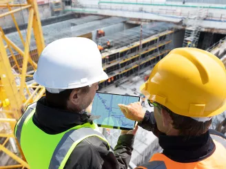 Construction workers on a construction site using a tablet