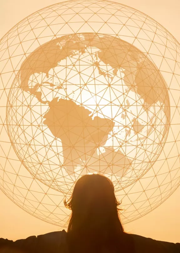 Globe illustration in front of a sunset